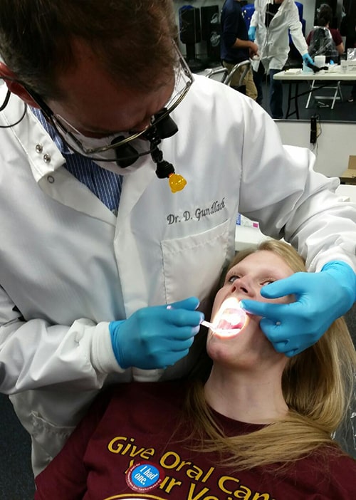 A Dental Associates dentist performs and oral cancer exam on a patient