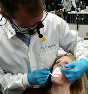 Dr. Donald Gundlach performs an oral cancer screening at the Oral Cancer Foundation 5K