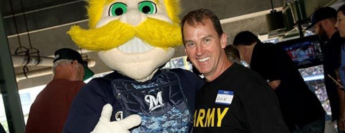 dental associates dentist posing with brewer's mascot Bernie