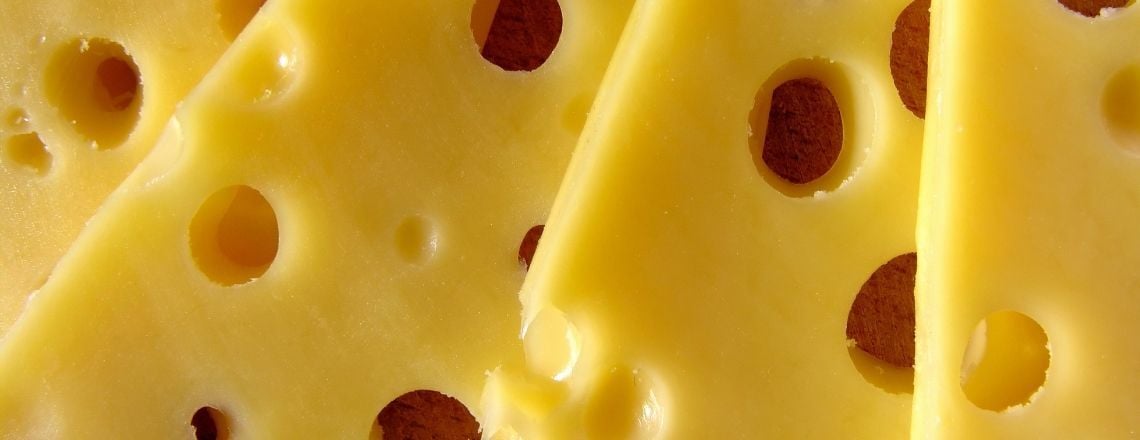 close up of swiss cheese with many holes 