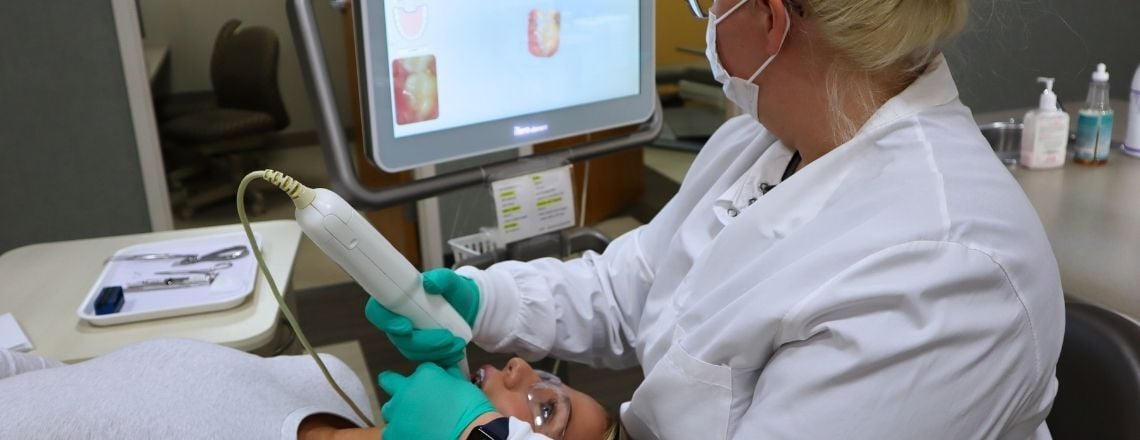 dental assistant using a digital dental scanner to take digital impressions