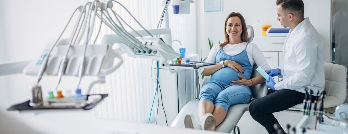pregnant woman sitting in dental chair 