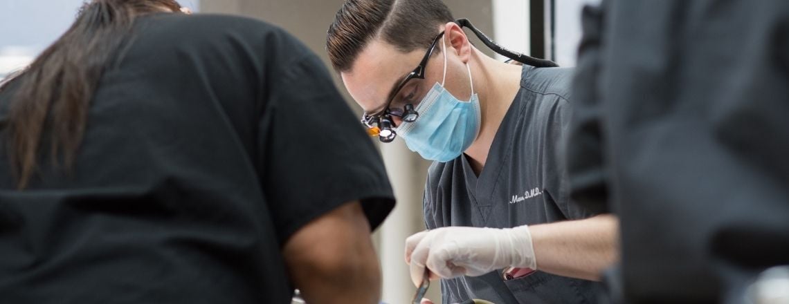 dentist working on patient while replacing teeth