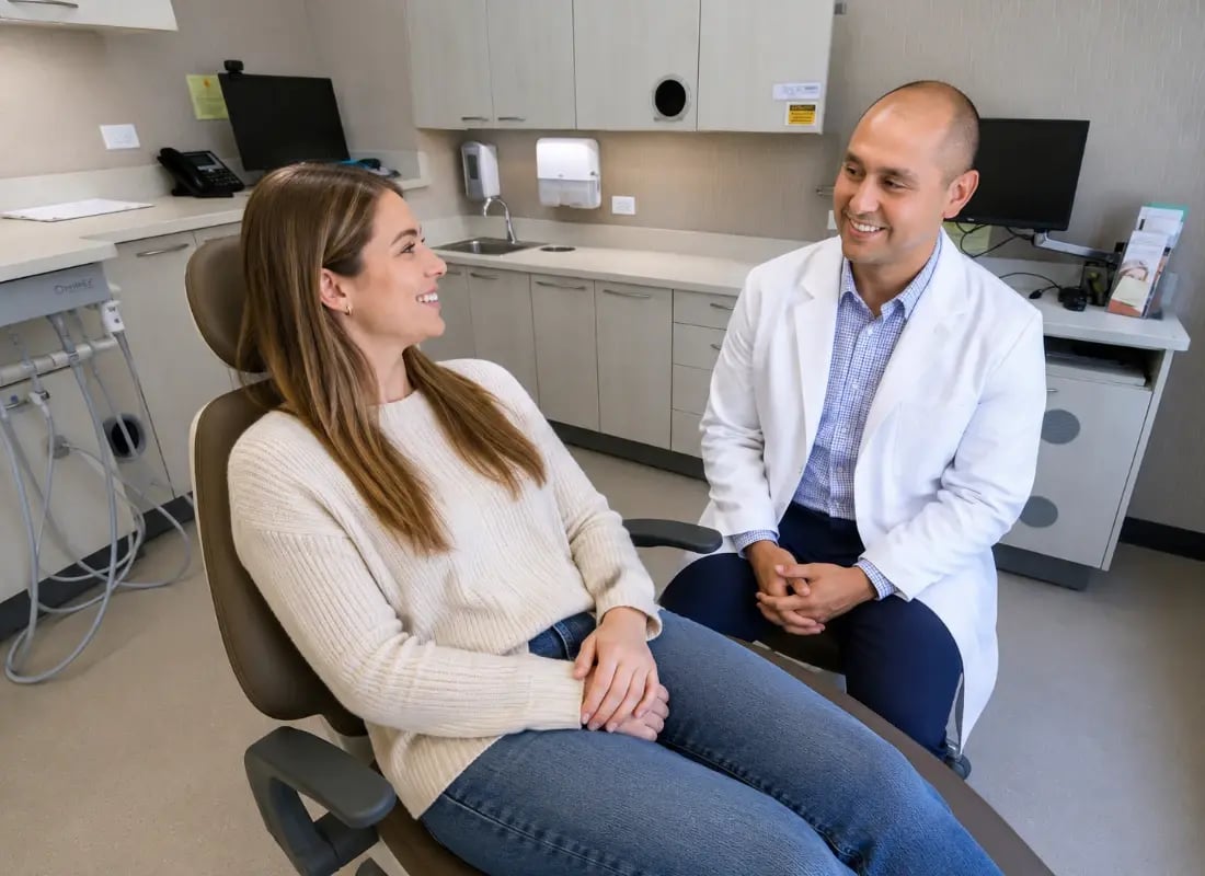 A female patient smiling in a dental chair during a consultation with her general dentist.