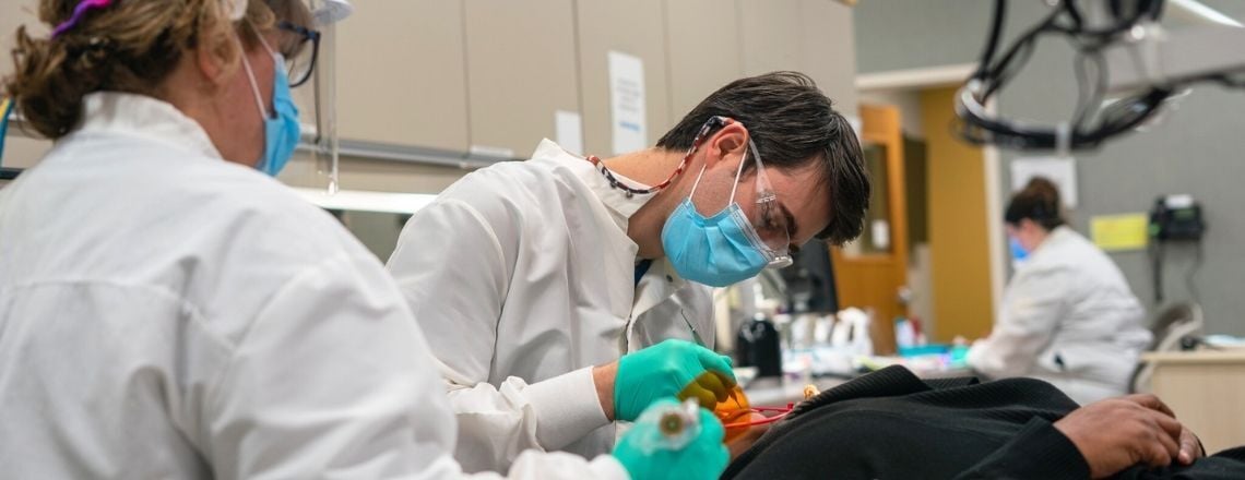 dentist examining a patient with a dental assistant