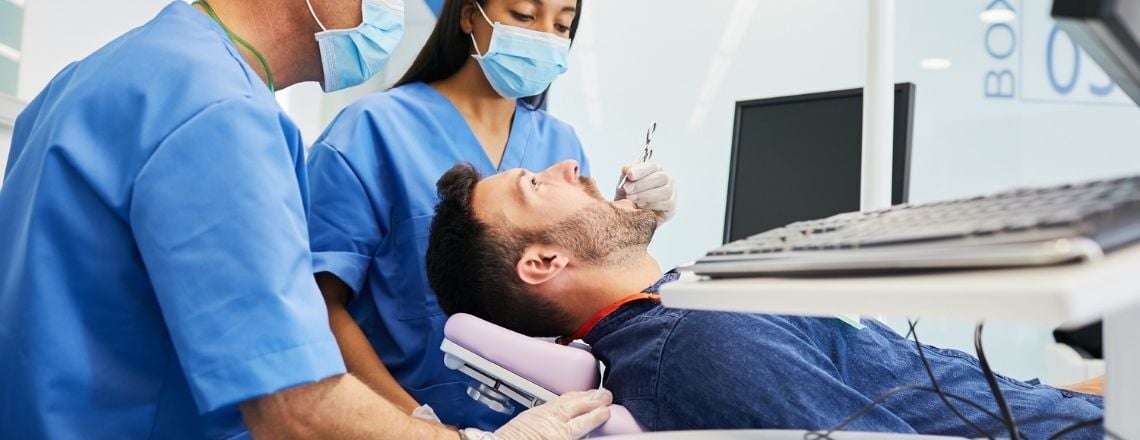 woman holding dental instruments working on a patient in the dental chair