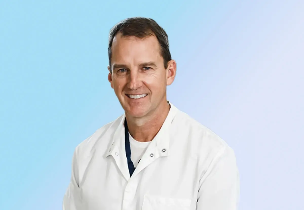 Dr. Don Gundlach wearing a white medical coat against a light blue background.